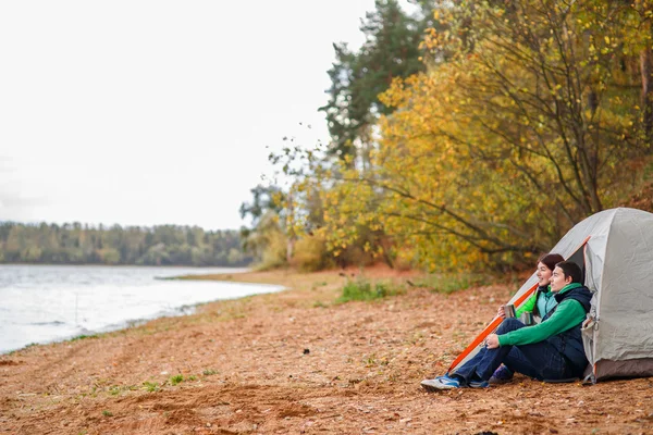 Kvinna och man sitter nära tält — Stockfoto