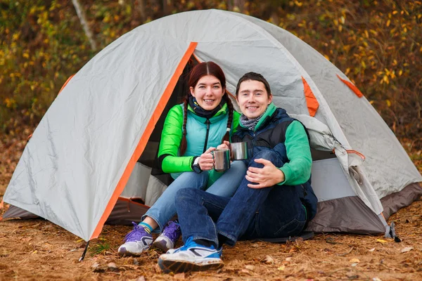 Kvinna och man sitter nära tält — Stockfoto