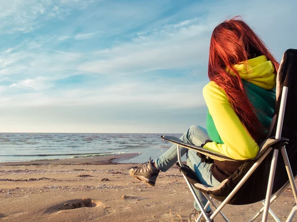 Vrouw zitten op strandstoel — Stockfoto