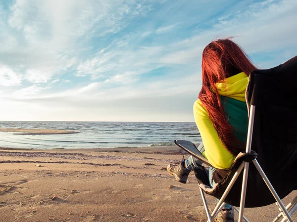 Vrouw zitten op strandstoel — Stockfoto