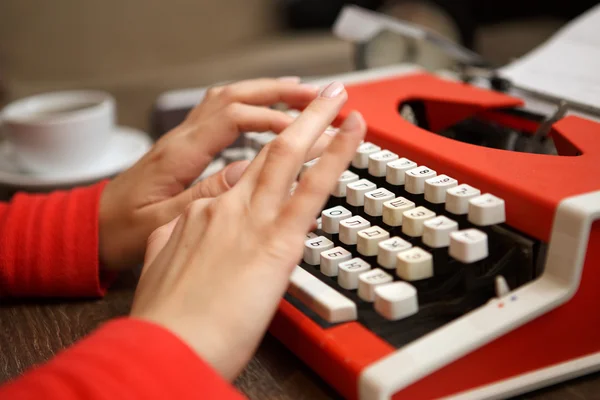 Menselijke handen schrijven op rode typemachine — Stockfoto