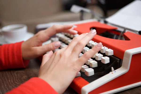 Menschliche Hände schreiben auf roter Schreibmaschine — Stockfoto
