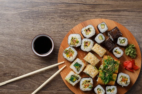 Sushi definido na placa de madeira redonda — Fotografia de Stock