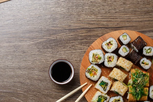 Sushi asetettu pyöreä puinen levy — kuvapankkivalokuva
