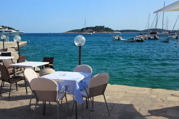 Tables of cafe on the embankment of the city of Hvar. — Stock Photo, Image