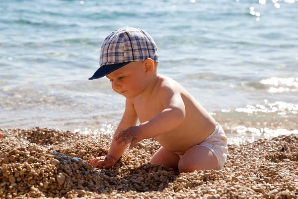 Het kleine kind speelt op een strand — Stockfoto