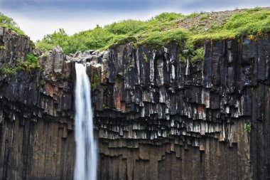 Basalt faces framed by water