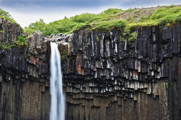 Basalt faces framed by water — 스톡 사진