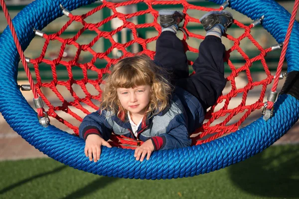 Pequeño niño balanceándose en un columpio — Foto de Stock