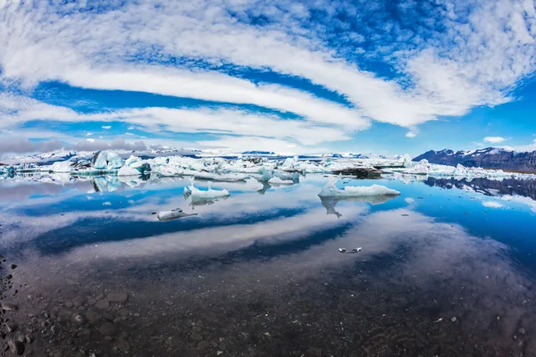 Nubes capas que se ventilan reflejadas en el agua — Foto de Stock