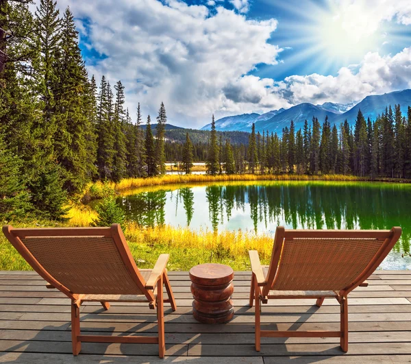 Wooden deckchairs on the shore of lake — Stock fotografie