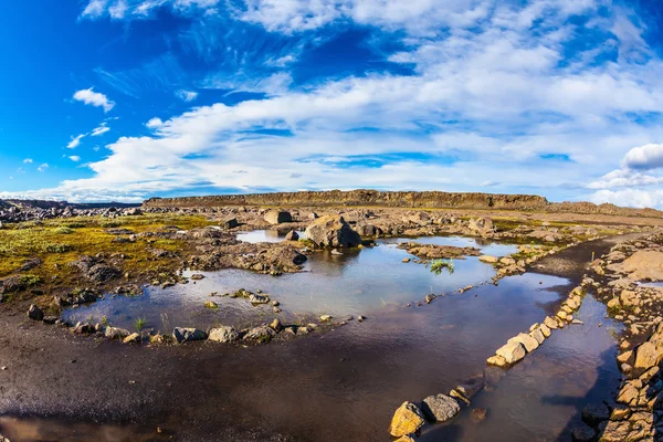 Pequeño charco y enormes piedras — Foto de Stock