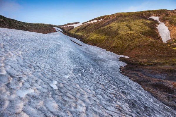 Grote ungesmolten in juli snowfield — Stockfoto