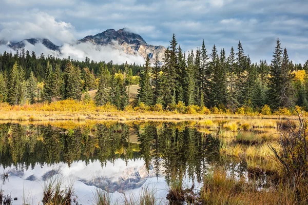 Berg och moln reflekteras i kallt vatten — Stockfoto