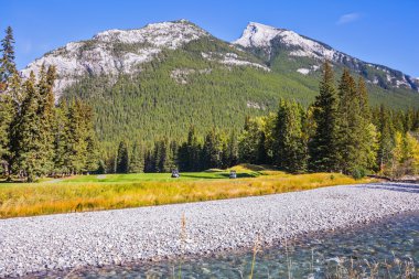 Dağlar arasında akarsu akar.