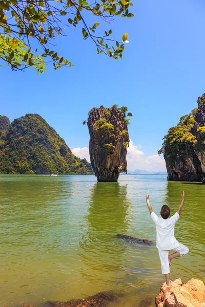 Woman performs yoga pose on the shore — Stock Photo, Image