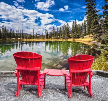 Gölde iki kırmızı plastik sandalye