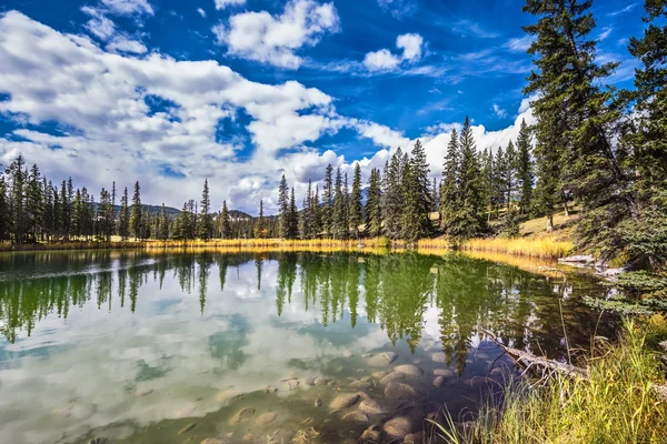 La superficie liscia dell'acqua riflette cielo nuvoloso — Foto Stock