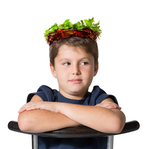 Jongen zit schrijlings op een stoel in Carnaval het dragen van een kroon — Stockfoto