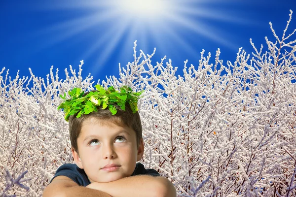 Charmig pojke i karnevalkrans av gröna blad — Stockfoto