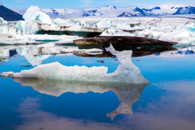  Soğuk yaz günü. Jokulsaurloun gölü. İzlanda. Garip buzdağları ve yüzen buz kütleleri gölün yumuşak soğuk suyuna yansıyor. Kuzey ve fotoğraf turizmi kavramı