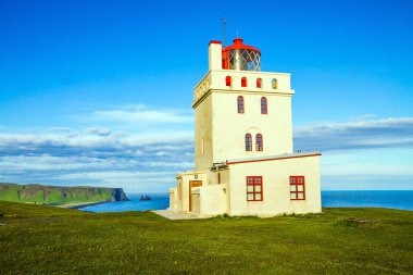 Cape Dyrholaey 'de. Adanın güney ucundaki antik deniz feneri. İzlanda 'nın muhteşem adasına git. Siyah volkanik kül olan plaj Reinisfjara. Ekstrem ve fotoğraf turnuvası konsepti