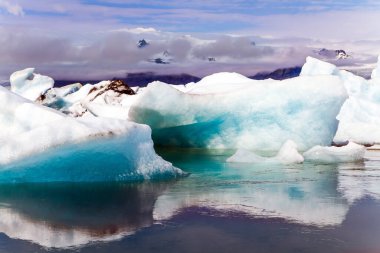Jokulsaurloun - İzlanda 'nın en büyük buzul gölü. Soğuk yaz sabahı. Beyaz ve mavi buzdağları ve buz kütleleri soğuk suda yüzer. Ekstrem, kuzey ve fotoğraf turizmi kavramı