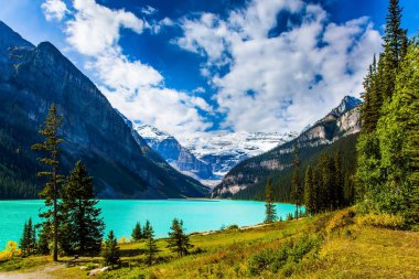 Göl masmavi suyla çevrili dağlar ve ormanlarla çevrilidir. Banff 'taki Buzul Gölü Louise, Kanada Kayalıkları. Güneşli güzel bir gün. Ekolojik, aktif ve fotoğraf turizmi kavramı