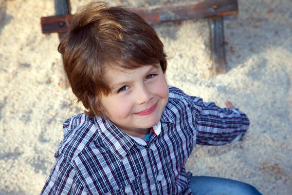 子供の遊び場で遊ぶカウボーイシャツの魅力的な少年 天気のいい日だ 写真広告と幸せな子供時代の概念 — ストック写真