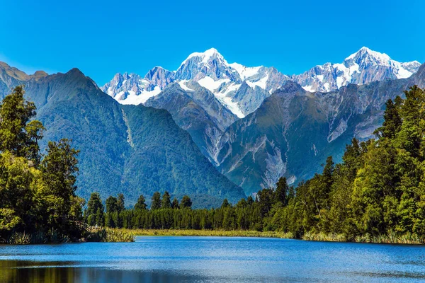 Agua Fría Suave Del Lago Matheson Rodeada Bosques Montañas Nevadas — Foto de Stock