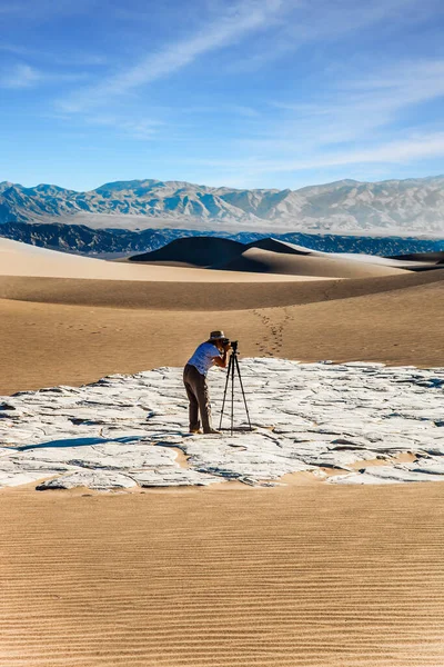 一个带着照相相机和三脚架的女人站在沙丘中间 加利福尼亚死亡谷的中间平坦的沙丘 积极旅游和摄影旅游的概念 — 图库照片