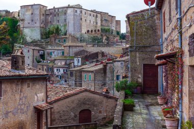Tufa şehri Sorano bir peri masalından büyülenmiş bir şehir. Dar sokaklar, taş basamaklar ve çiçek saksıları. İtalya, Toskana. Etkin, tarihi ve fotoğraf turizmi kavramı