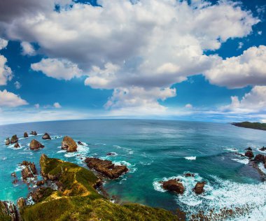 Nugget Points yakınlarında Pasifik Okyanusu 'nun pitoresk sahili. Kıyı boyunca büyük taşlar. Fotoğraf Fisheye lens tarafından çekildi. Yeni Zelanda. Aktif, çevresel ve fotoğraf turizmi kavramı