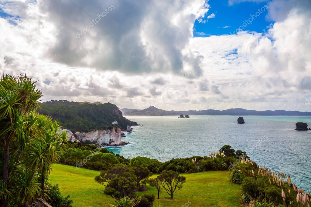 The road to Cathedral Cove. Lush clouds of strange shapes over picturesque exotic trees and bushes. New Zealand. Travel to the edge of the Earth. The concept of exotic and photo tourism