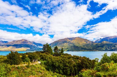Güney Adası. Siren bulutları gökyüzünde uçar. Renkli dağların arasındaki gök mavisi göl. Yeni Zelanda 'daki güzel Wanaka Gölü. Etkin, ekolojik ve fotoğraf turizmi kavramı