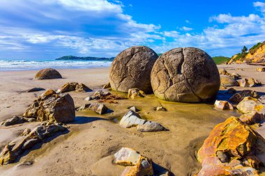 Popüler turist merkezi. Devasa yuvarlak kaya parçaları grubu Moeraki ve kalıntıları. Pasifik Okyanusu 'ndaki kumsal, Yeni Zelanda. Egzotik ve ekolojik turizm kavramı