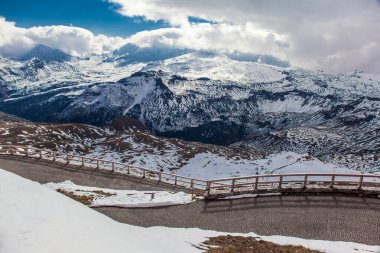 Dik taşlı viraj. Yol kenarı çitlerle çevrili. İlk kar yağdı. Grossglockner Alpine Yolu, Avusturya. Ekolojik, aktif ve fotoğraf turizmi kavramı