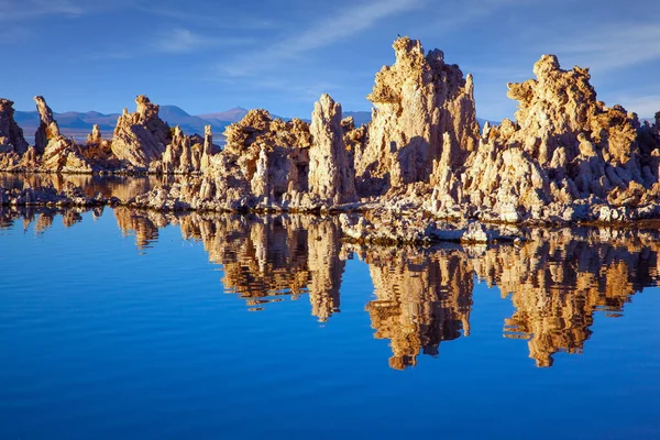 Lime-tuff towers of bizarre shapes rise from the bottom of the lake. The natural wonder of the world is Lake Mono. Magic reflections of tuff outliers in lake water. Magic sunrise on the lake.