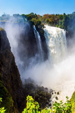 Şelalenin üzerinde dev bir sis bulutu. Victoria Ulusal Parkı. Zambezi Nehri 'ndeki Victoria Şelalesi. Yağmur mevsiminden sonra yolculuk. Ekstrem ve fotoğraf turizmi kavramı