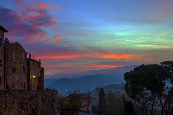 The stunning landscape of the valley is photographed from wall around the city. Tuscany. The edge of the sky turns pink. The concept of active, architectural and photo tourism