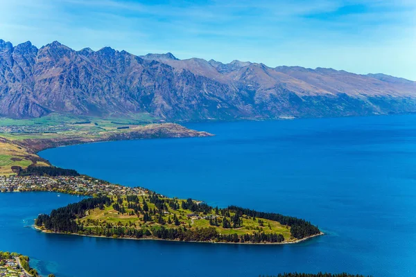 Bird's eye view. The city - resort Queenstown, shores of Lake Wakatipu. Travel to New Zealand, South Island. Huge azure lake among the mountains. The concept of active, ecological and photo tourism