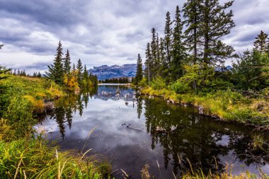  Kanada 'nın gölleri, köknar ve dağları. Bulutlu gökyüzü pürüzsüz su yüzeyine güzel bir şekilde yansıyor. Pocahontas yolu boyunca uzanan vadi. Etkin ve fotoğraf turizmi kavramı 