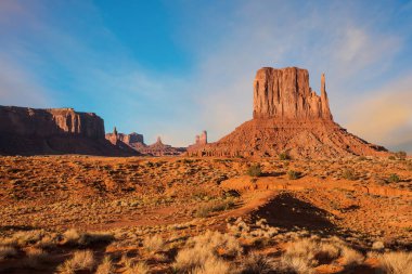 Anıt Vadisi 'ndeki ünlü uçurum eldivenleri. Kayalar - kırmızı kumtaşından yapılmış çıkıntılar. Kızıl Taş Vadisi 'nde çok renkli gün batımı. Aktif, çevresel ve fotoğraf turizmi kavramı