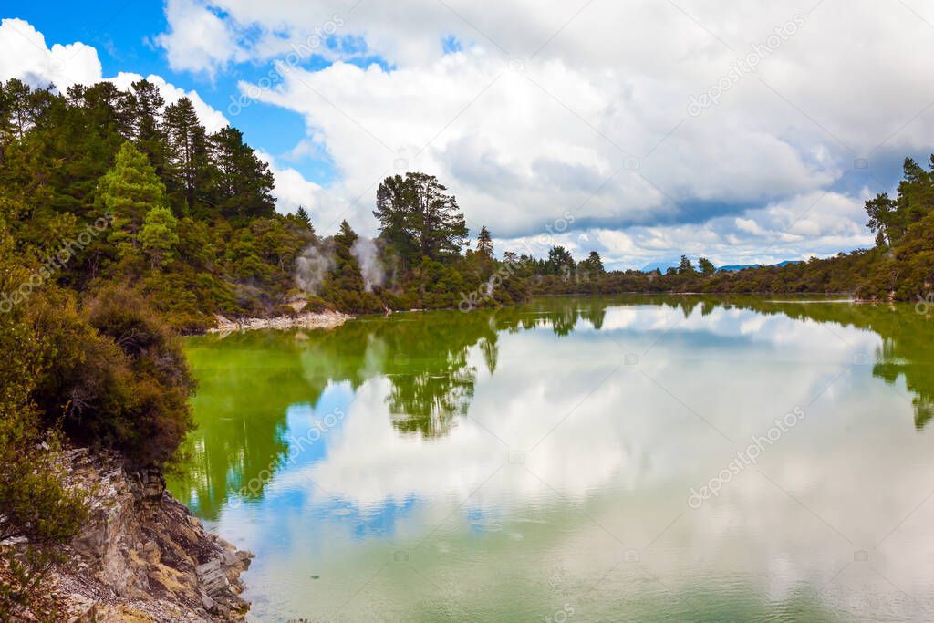 Wai-O-Tapu Geyser Park. Cumulus clouds are picturesquely reflected in the smooth surface of hot water. New Zealand, North Island. The concept of exotic, ecological and photo tourism