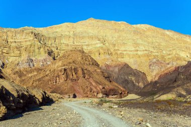 İsrail dağlarındaki yıpranmış kumtaşı. Eilat Dağları 'ndaki toprak yol. Renkli peyzaj oluşumları. Kasım günü. 