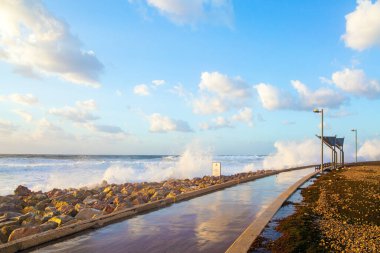 Tel Aviv 'de toprak seti. Gün batımı. Güçlü kış sörfü kar beyazı köpükle kalkıyor. Akdeniz kıyısında rüzgarlı ve güneşli bir gün. Akdeniz 'de kış fırtınası. İsrail.