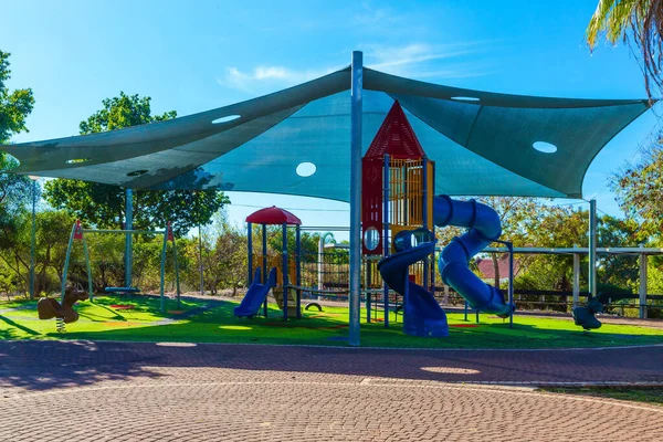 Great children 's playground with a variety of color attractions. Special tent is pulled over the playground. Bright warm sunny morning. Concept of physical and mental development of childre