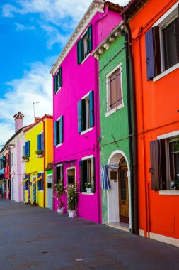 Burano, Venedik yakınlarında çok renkli parlak evler adasıdır. Veneto vilayeti. Pencereler çiçeklerle süslenmiş. Kültür, tarih ve fotoğraf turizmi kavramı