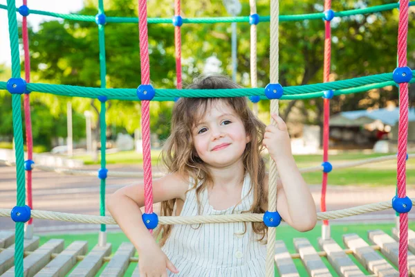 温暖的夏日 可爱的小女孩 金发碧眼 身穿白衣 绿化公园的游乐场吸引人 — 图库照片