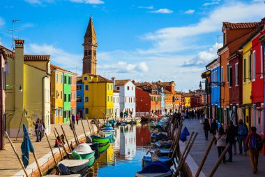 Venedik. Eğimli kule ve renkli evler Burano kanallarına yansıyor. Tekneler kanalların kıyıları boyunca park halindedir. Kültür ve fotoğraf turizmi kavramı